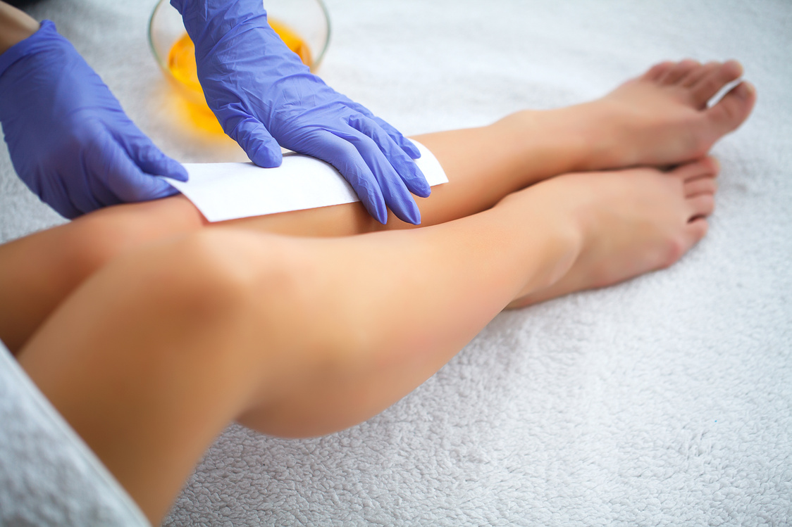 Waxing. Beautician Waxing Woman's Leg In Spa Salon